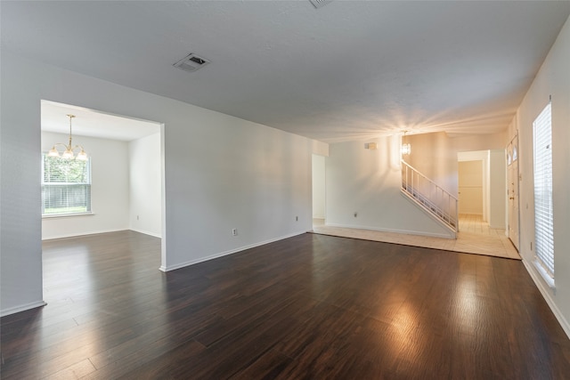 unfurnished room with dark hardwood / wood-style flooring and an inviting chandelier