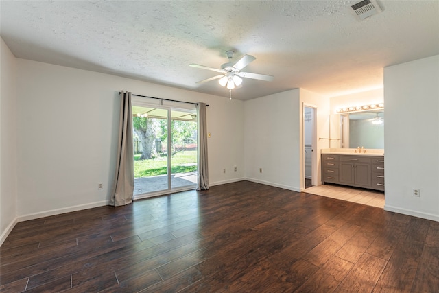 interior space featuring ceiling fan, sink, wood-type flooring, and a textured ceiling