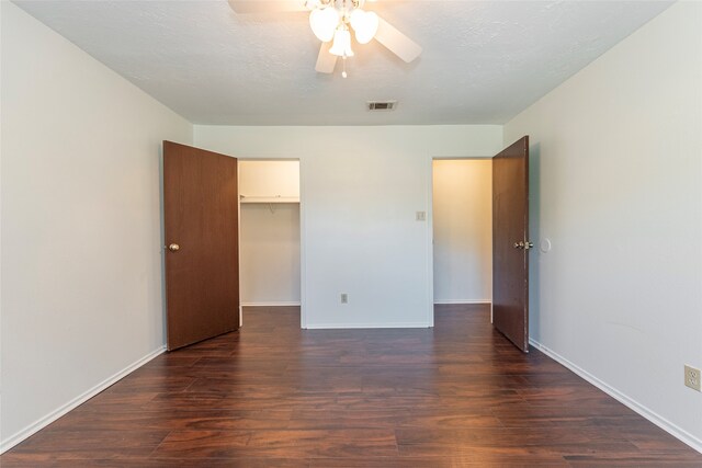 empty room featuring ceiling fan, dark hardwood / wood-style flooring, and a textured ceiling