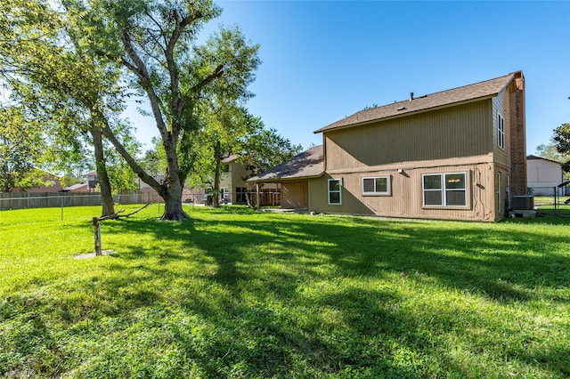 back of house featuring a lawn and central AC unit