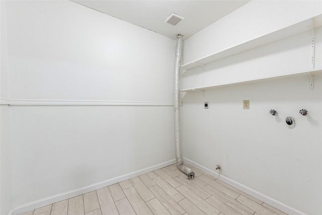 washroom with electric dryer hookup, hookup for a washing machine, hookup for a gas dryer, and light hardwood / wood-style flooring