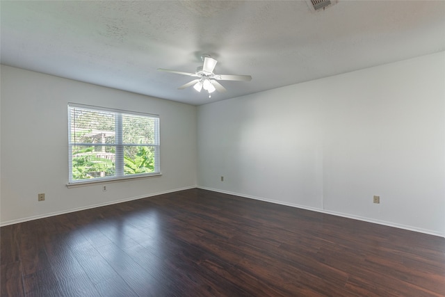 empty room featuring ceiling fan, dark hardwood / wood-style flooring, and a textured ceiling