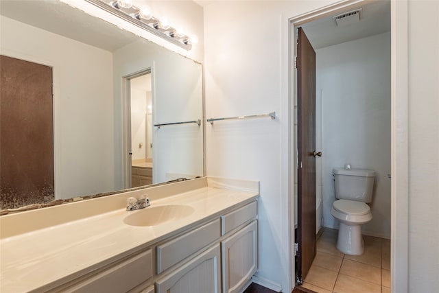 bathroom with tile patterned flooring, vanity, and toilet