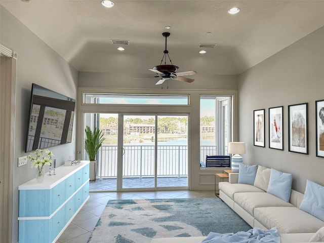 living room featuring vaulted ceiling, ceiling fan, and light tile patterned flooring