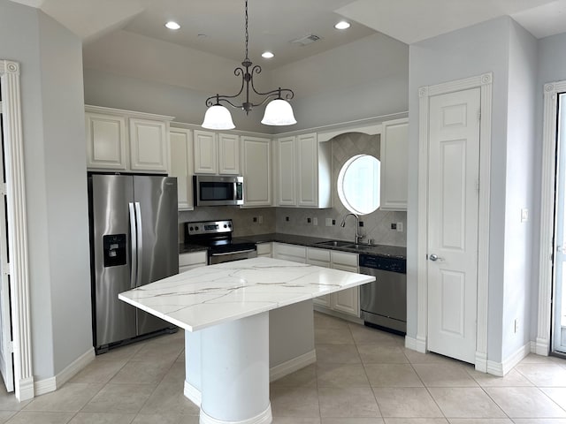 kitchen featuring sink, decorative backsplash, decorative light fixtures, a kitchen island, and stainless steel appliances