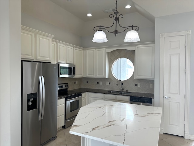 kitchen featuring sink, hanging light fixtures, a kitchen island, white cabinetry, and stainless steel appliances