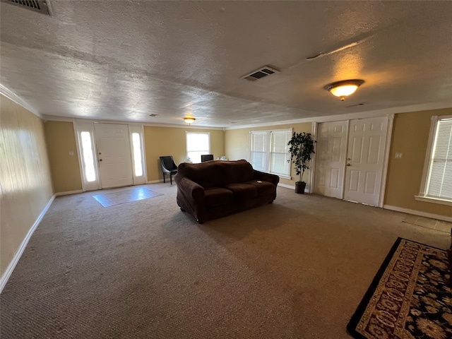 living room with carpet floors, a textured ceiling, and ornamental molding