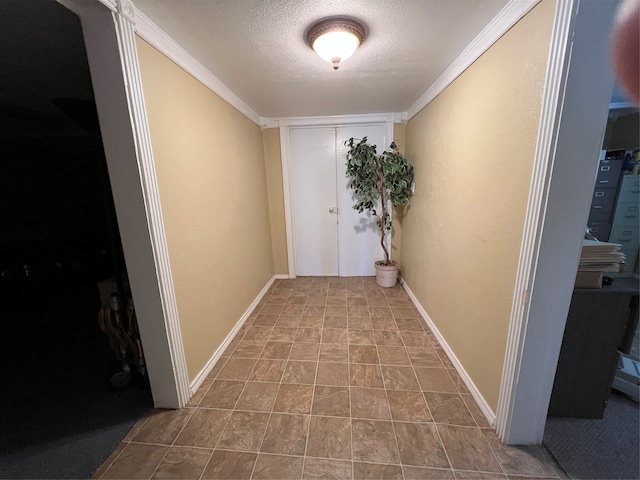 hall with a textured ceiling and ornamental molding