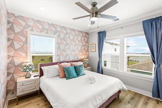 bedroom with ceiling fan, light wood-type flooring, ornamental molding, and multiple windows