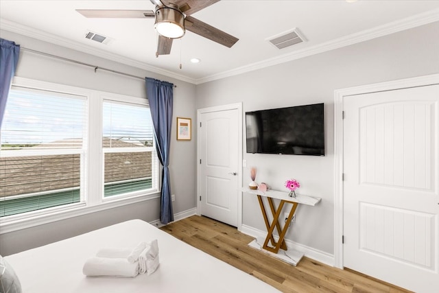 bedroom with ceiling fan, crown molding, and hardwood / wood-style flooring