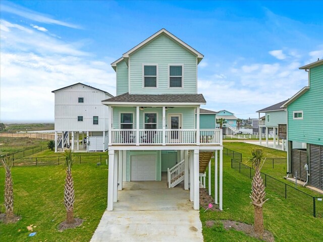 view of front of home with a front lawn, covered porch, and a garage