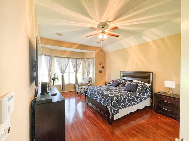 bedroom with ceiling fan, lofted ceiling, and hardwood / wood-style flooring