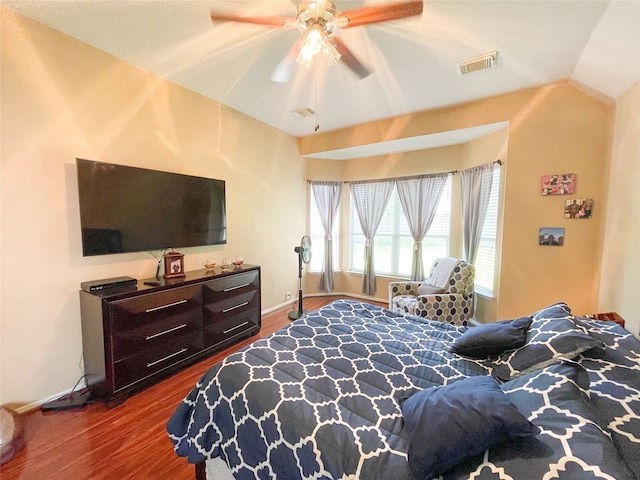 bedroom with ceiling fan, hardwood / wood-style floors, and vaulted ceiling