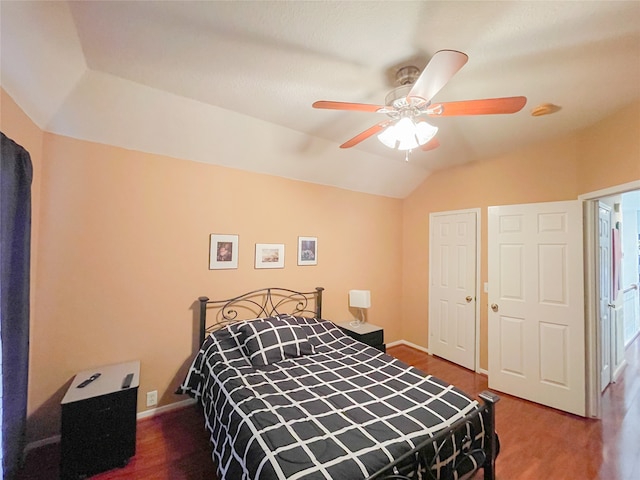 bedroom with ceiling fan, wood-type flooring, and lofted ceiling