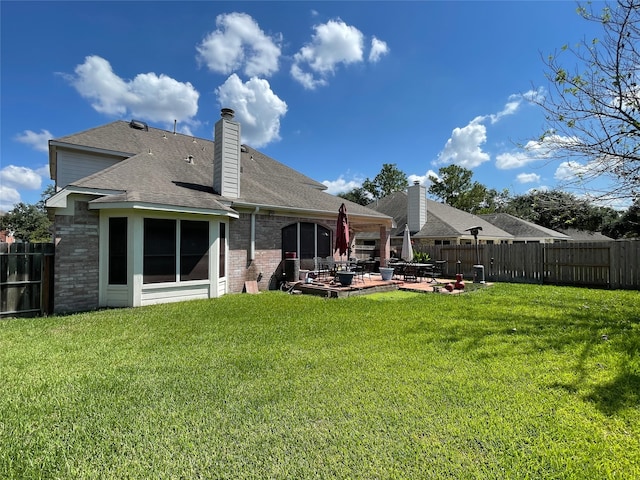 rear view of house featuring a patio area and a yard