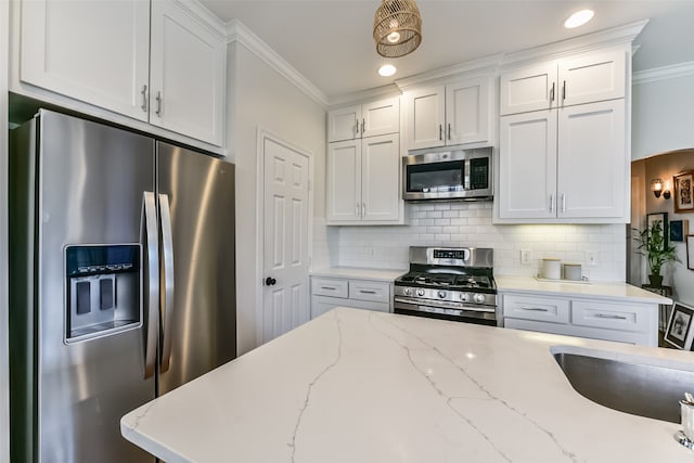 kitchen featuring backsplash, light stone counters, white cabinets, and appliances with stainless steel finishes