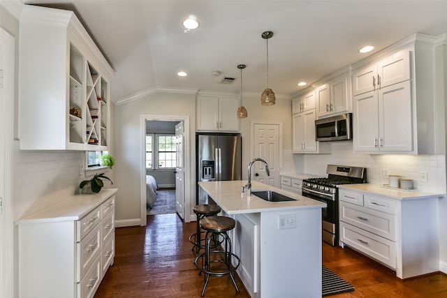 kitchen with appliances with stainless steel finishes, dark hardwood / wood-style flooring, sink, a center island with sink, and white cabinetry