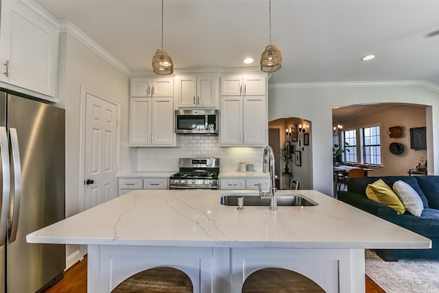 kitchen featuring white cabinets, pendant lighting, stainless steel appliances, and sink