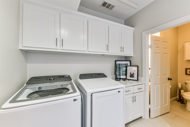 laundry area featuring cabinets, independent washer and dryer, and light hardwood / wood-style floors