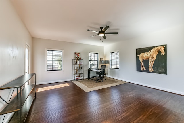 unfurnished office with ceiling fan and dark hardwood / wood-style flooring