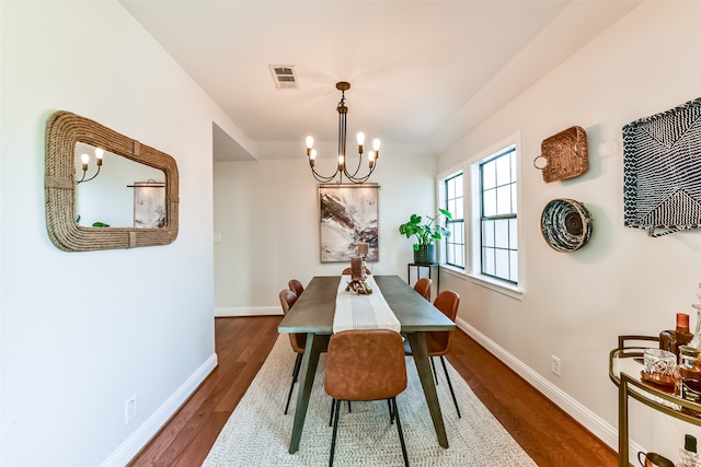 dining space with a notable chandelier and dark hardwood / wood-style flooring