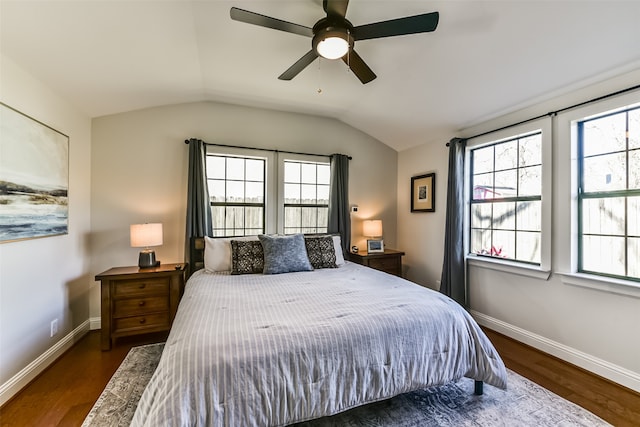 bedroom with vaulted ceiling, multiple windows, dark wood-type flooring, and ceiling fan