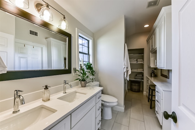 bathroom featuring toilet, vanity, and tile patterned floors