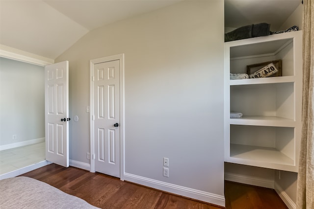 bedroom with lofted ceiling and dark hardwood / wood-style floors