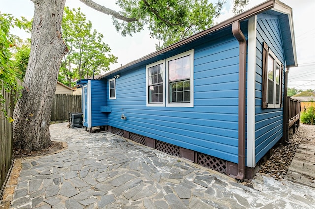 view of side of property featuring central air condition unit and a patio