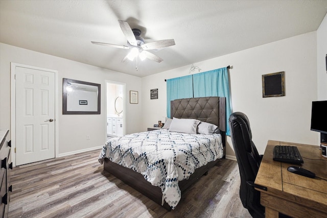 bedroom with ensuite bath, ceiling fan, and hardwood / wood-style floors