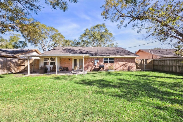 rear view of property with french doors, a patio, and a lawn