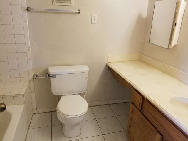 bathroom with tile patterned flooring, vanity, toilet, and a washtub