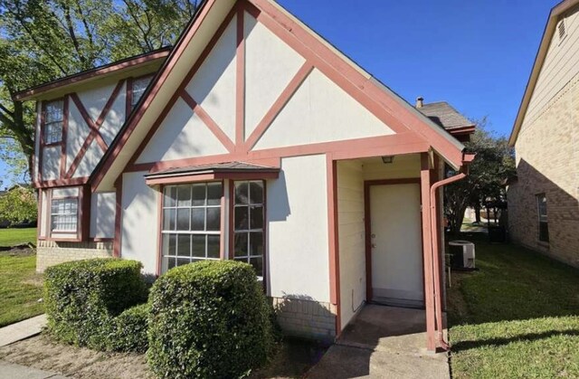 exterior space with central AC and a front lawn