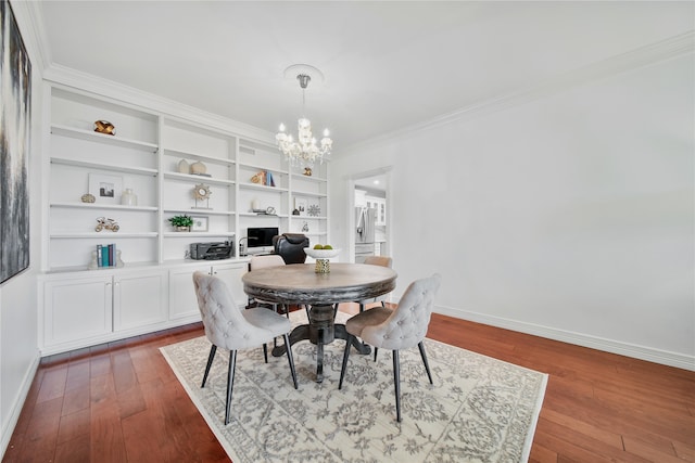 dining space with built in shelves, dark hardwood / wood-style flooring, ornamental molding, and a chandelier