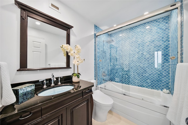 full bathroom featuring combined bath / shower with glass door, vanity, and toilet