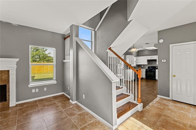 staircase with tile patterned flooring and a fireplace