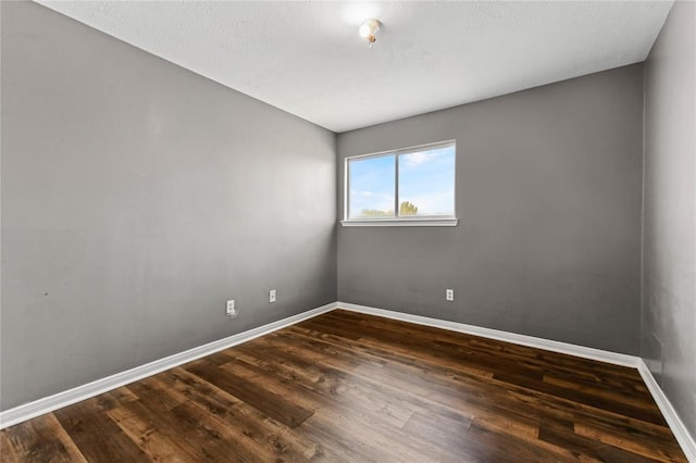 spare room with dark hardwood / wood-style flooring