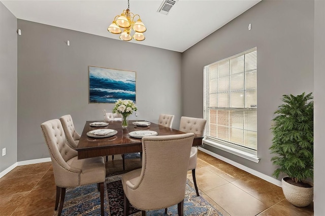 dining area featuring tile patterned flooring, a healthy amount of sunlight, and an inviting chandelier