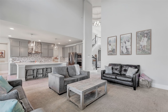 carpeted living room with a high ceiling and a chandelier