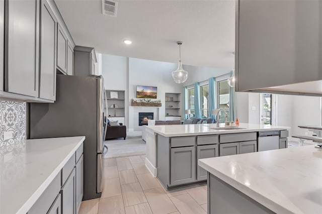 kitchen with stainless steel appliances, gray cabinetry, sink, and hanging light fixtures