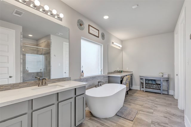 bathroom with shower with separate bathtub, vanity, and hardwood / wood-style floors