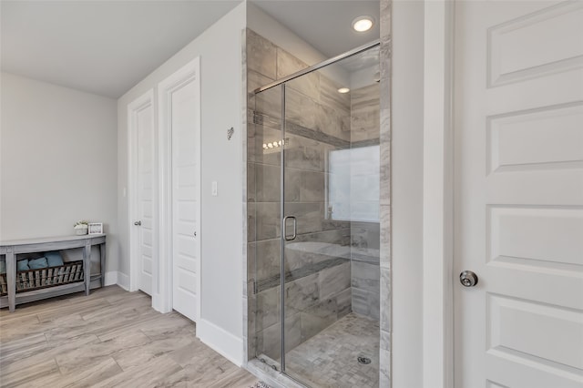 bathroom with hardwood / wood-style floors and a shower with door