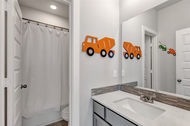 full bathroom featuring shower / tub combo, vanity, toilet, and backsplash