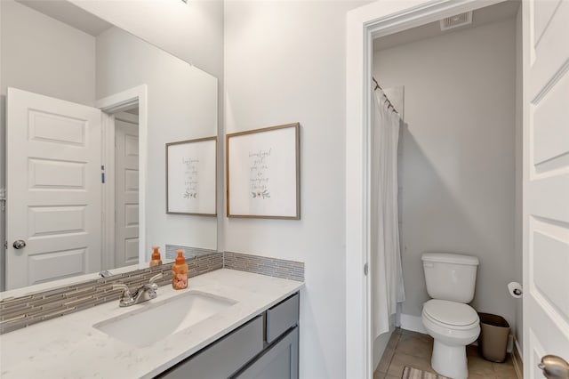 bathroom with tile patterned floors, vanity, toilet, and walk in shower