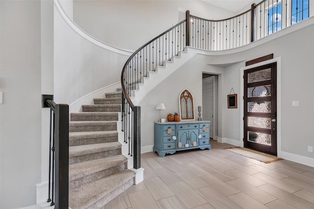 foyer entrance featuring light wood-type flooring and a towering ceiling