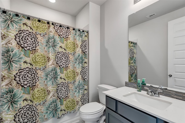 bathroom featuring decorative backsplash, vanity, and toilet