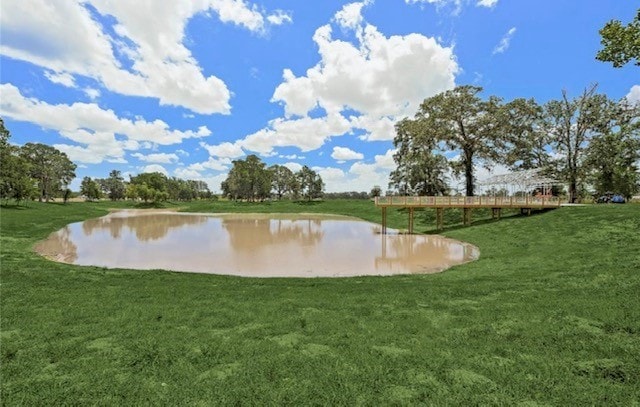 surrounding community featuring a lawn and a water view