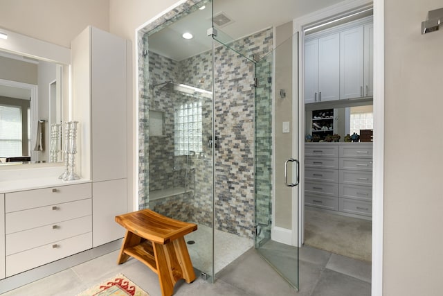 bathroom with tile patterned floors and a shower with door