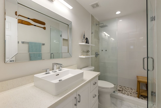 bathroom featuring a shower with door, vanity, and toilet