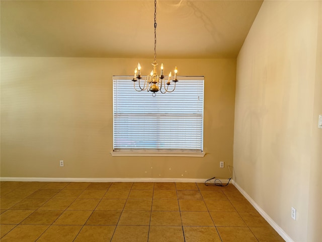 tiled empty room featuring a notable chandelier